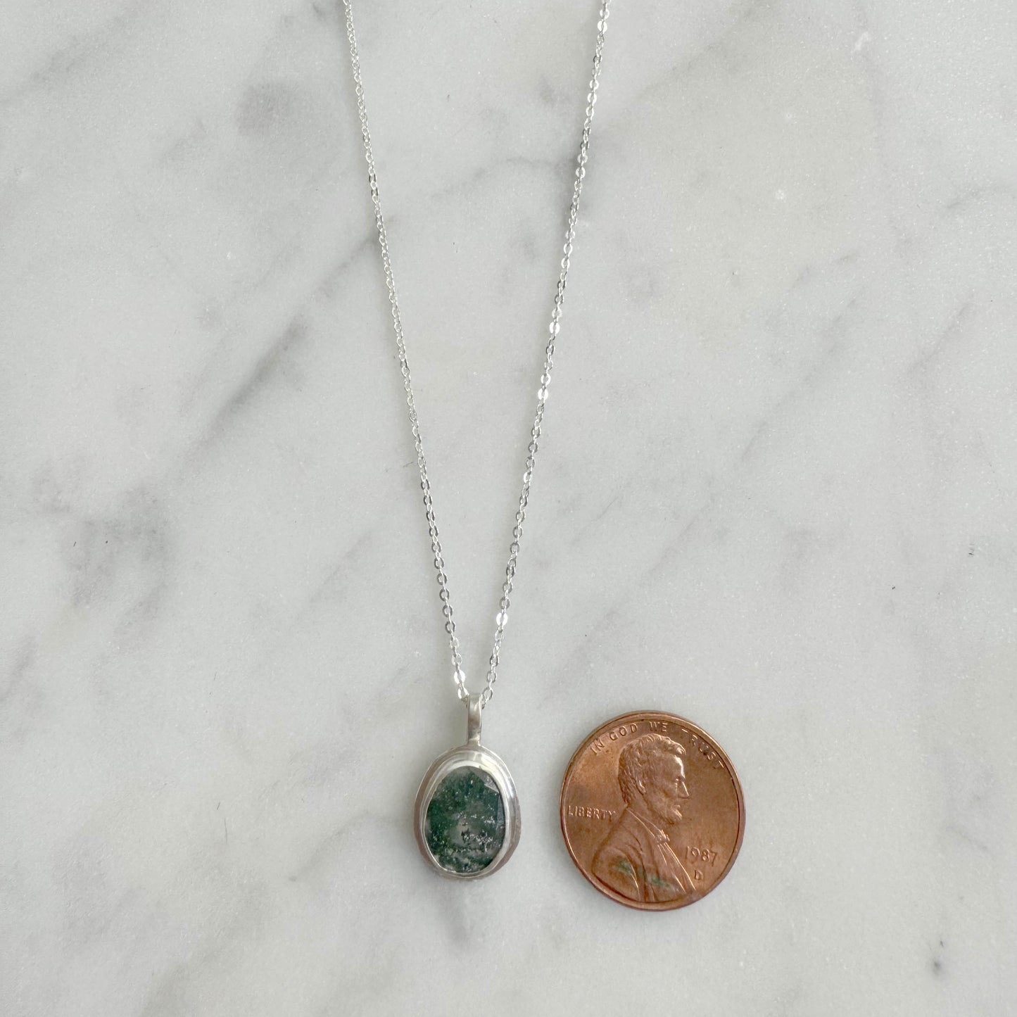 Moss Agate necklace next to penny