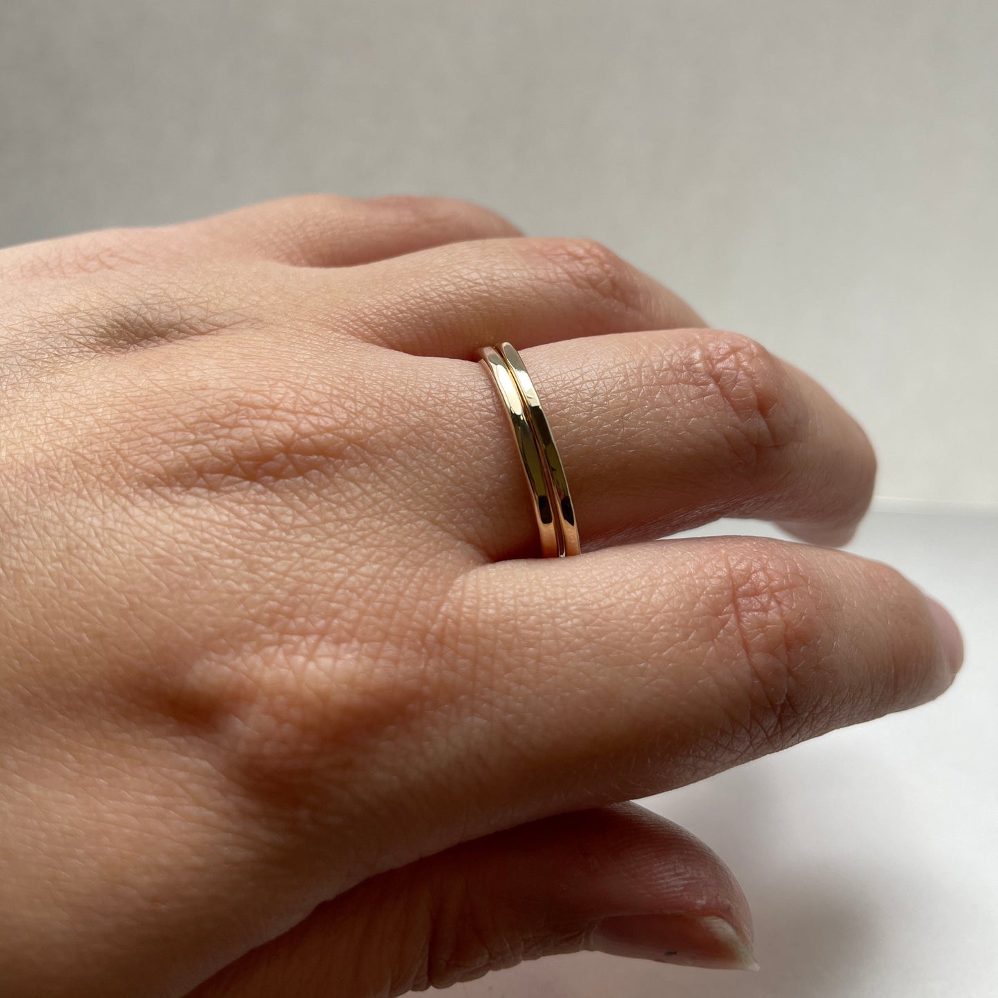 Petite faceted hammered band double stacked on finger