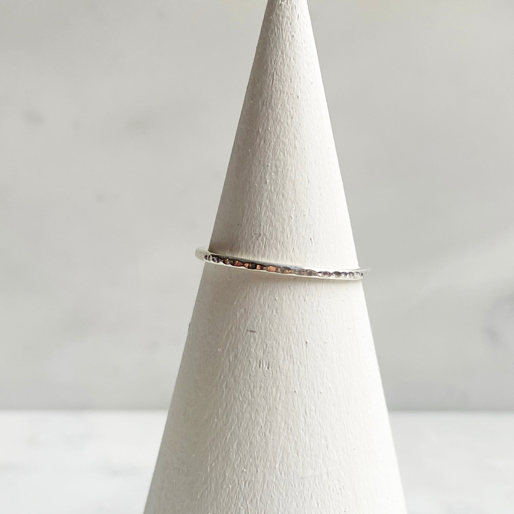 Extra Petite Line hammered band in silver on ring cone