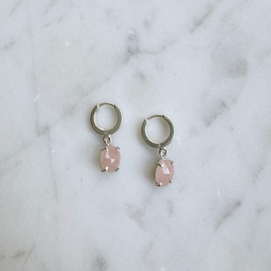 guava quartz huggie hoops in silver on marble background