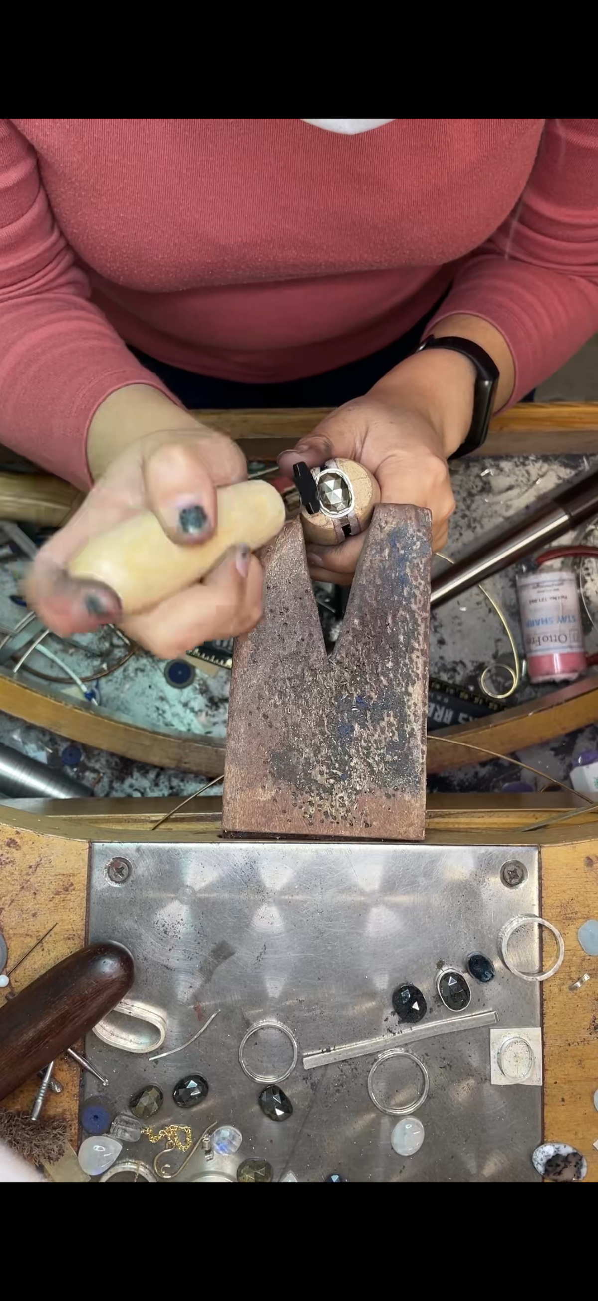 Person working with jewelry tools on a workbench